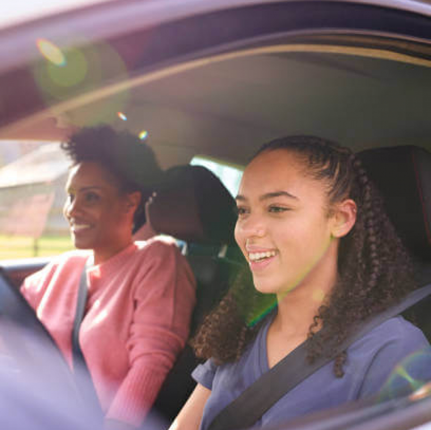 Teenage Girl In Car Having Driving Lesson From Female Instructor Or Parent